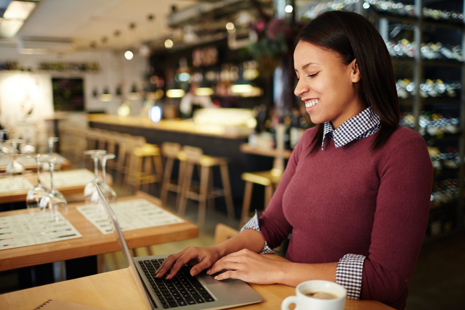 Mulher mexendo em computador fazendo marketing para restaurante
