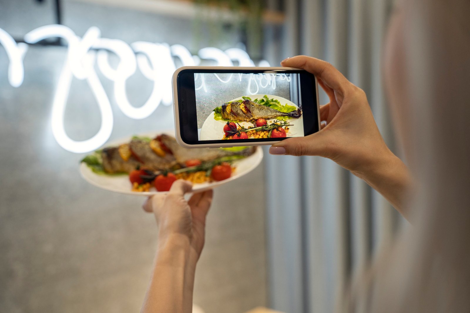 Homem com celular na mão fazendo fotos para cardápio