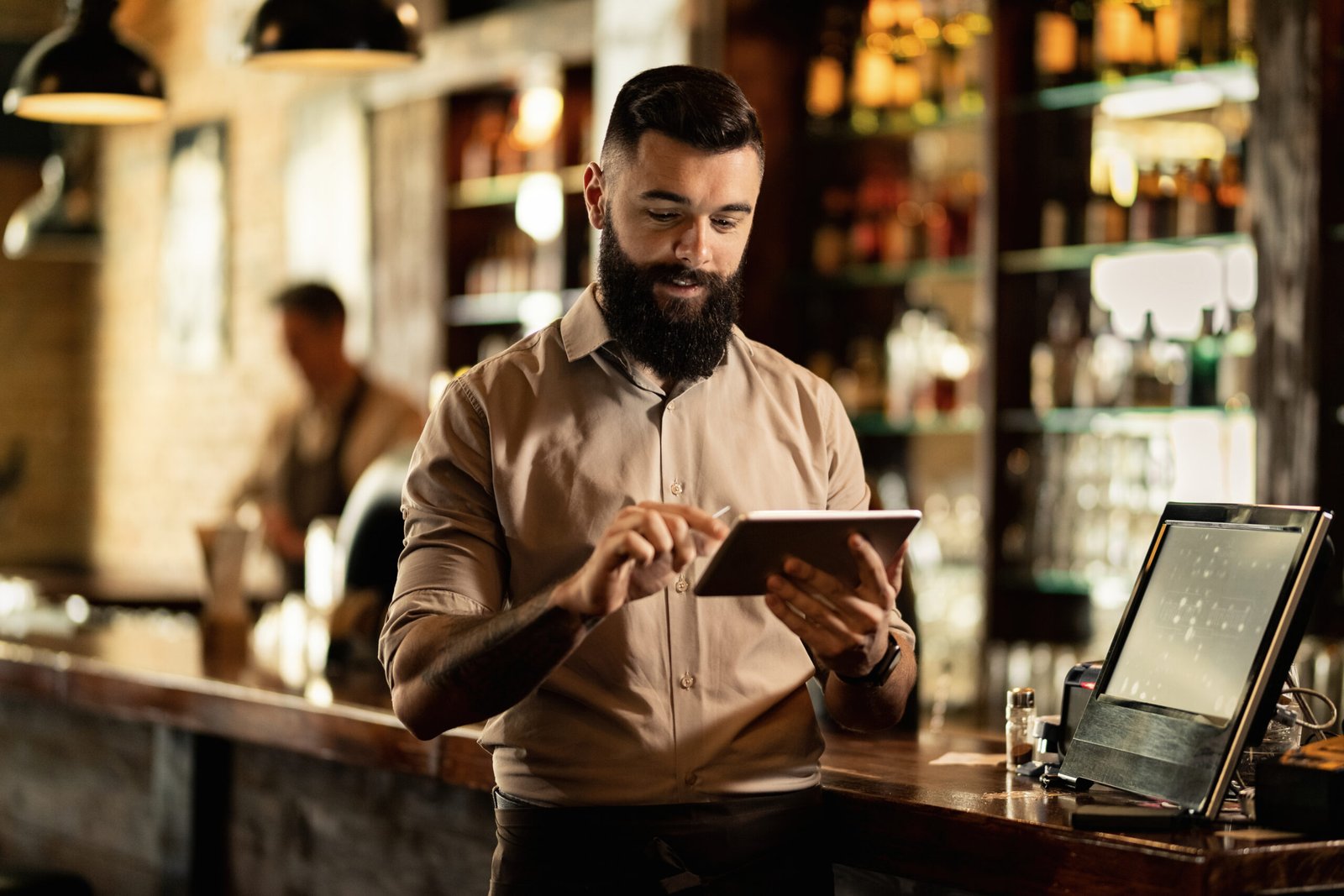 Garçom utilizando os melhores sistemas de reserva para restaurantes