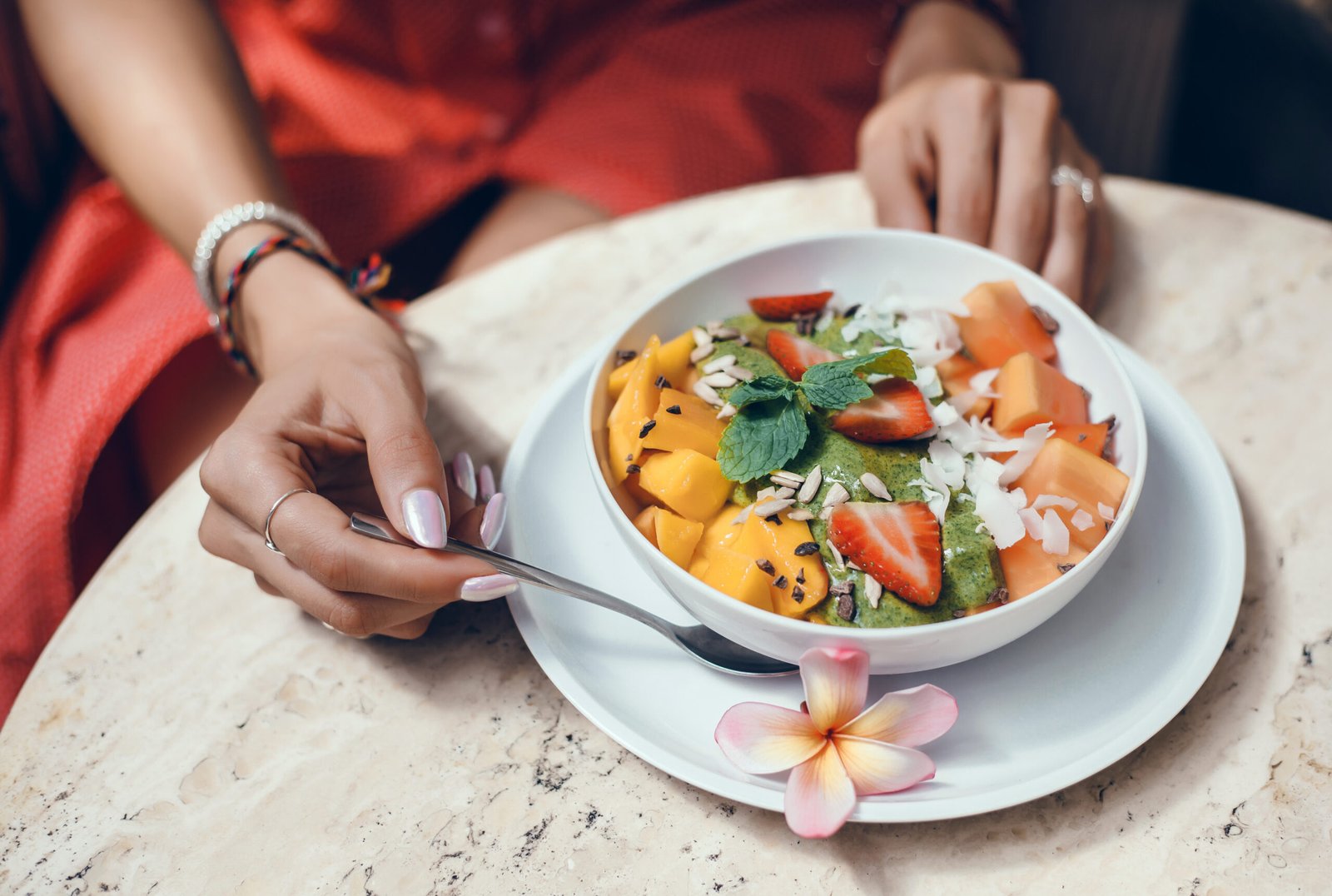 Bowl de frutas frescas e smoothie verde servido em café, exemplo de cardápio de verão.