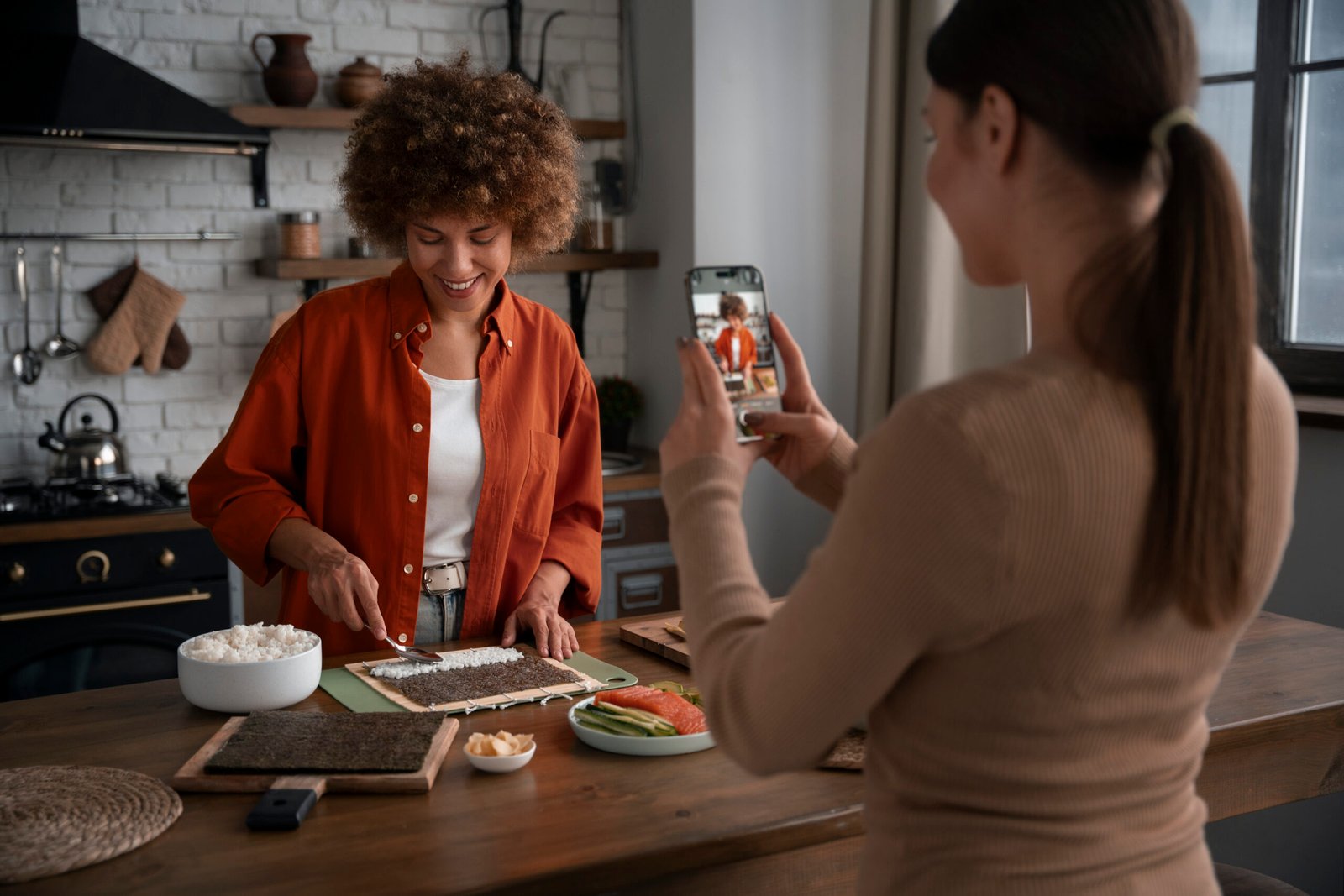 Mulher grava preparo de sushi em cozinha, criando storytelling para restaurante com conteúdo autêntico e humano.