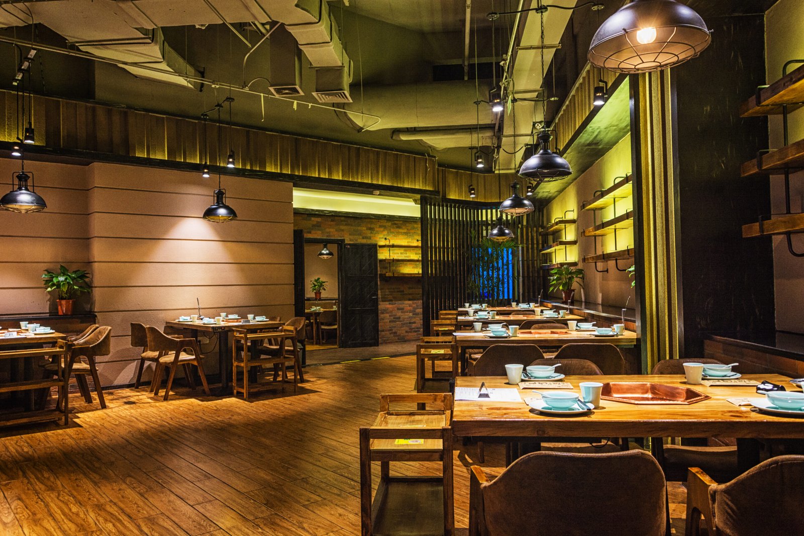 Interior de restaurante moderno com mesas organizadas e ambiente aconchegante, representando estratégias de gestão para aumentar o RevPASH no restaurante.